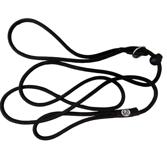 A black braided rope dog leash with a black rubber ball tip and metal ring, laid flat on a gray and white marble surface.